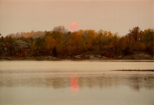 A cloudy Sun Rise over a lake in Canada from our Campground where loons serenaded us